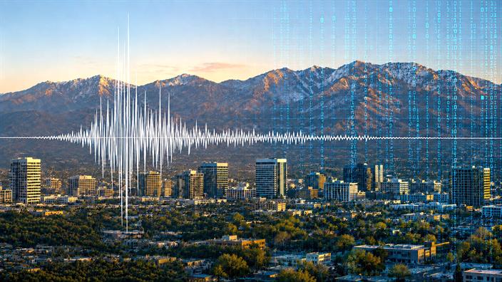 A.I. generated image of a city and mountain landscape overlaid with a stylized seismic waveform representing earthquake data